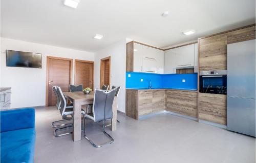 a kitchen with a table and chairs and a refrigerator at Amazing Apartment In Pag With Wifi in Pag