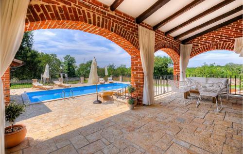 een patio met een zwembad en een boog bij Villa Oxalis in Poreč