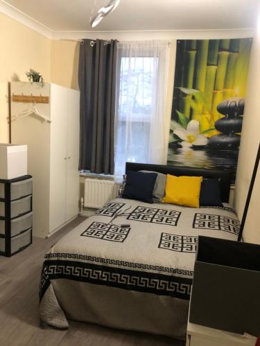 a bedroom with a bed and a painting on the wall at Blue Room, twin in London
