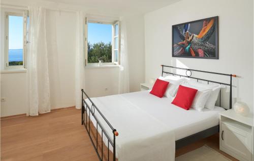 a bedroom with a large white bed with red pillows at 4 Bedroom Awesome Home In Lun in Lun