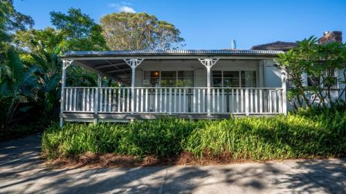 a house with a porch with a white railing at Bali Huts Escape in Nowra