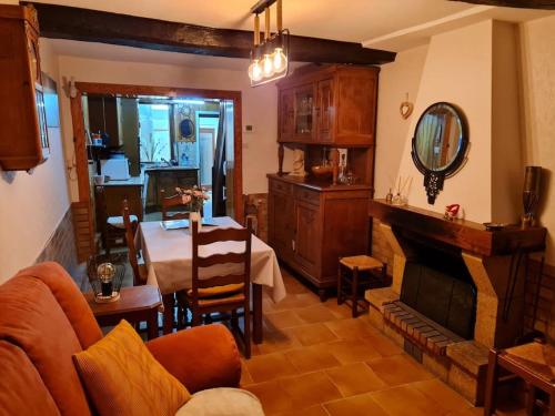 ein Wohnzimmer mit einem Sofa, einem Tisch und einem Spiegel in der Unterkunft La Petite Maison Pa'Meuse in Monthermé