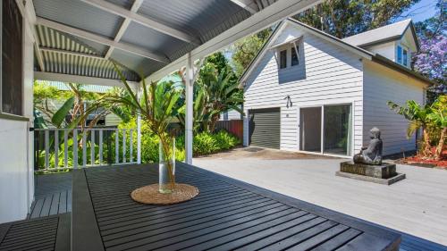 a porch with a palm tree on it at Bali Huts Escape in Nowra