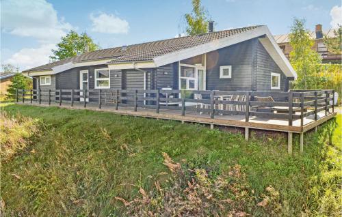 a blue house with a deck and chairs at Holiday Home Sydbakken Ebeltoft in Ebeltoft
