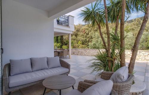 a patio with a couch and chairs and palm trees at Pet Friendly Home In Sveti Jakov in Sveti Jakov