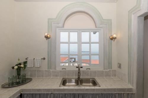 a kitchen sink with a window in a room at Villa Caprichosa Boutique Hotels in Taboga