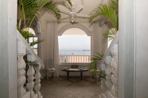 a hallway with a table and a large window at Villa Caprichosa Boutique Hotels in Taboga