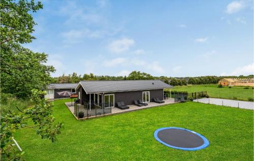 a house with a large backyard with a trampoline at Stunning Home In Væggerløse With Wifi in Marielyst
