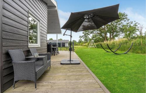a patio with a table and an umbrella at Stunning Home In Væggerløse With Wifi in Marielyst
