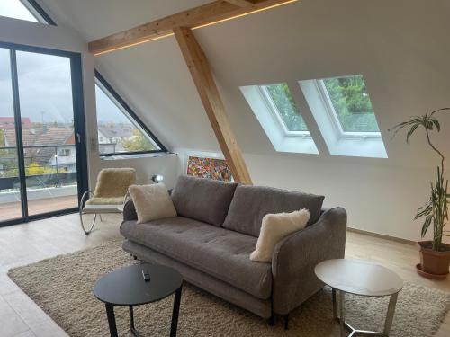 un salon avec un canapé et quelques fenêtres dans l'établissement L'écrin du vignoble, à Wettolsheim