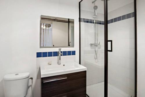 a white bathroom with a sink and a shower at Appartement Rosalia, cosy & central in Fort-de-France