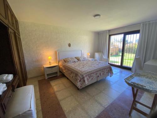 a bedroom with a bed and two tables and a window at Amplia, 4 dormitorios y piscina climatizada in Punta del Este