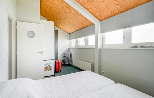 a bedroom with a white bed with a wooden ceiling at 3 Bedroom Amazing Home In Wieringerwerf in Wieringerwerf