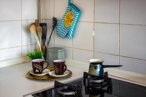 a kitchen counter with two coffee cups on a stove at Dalmatinska Cheyf Retreat in Sarajevo