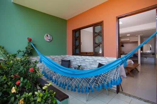 a hammock in the living room of a house at Pousada Timoneiro in Vila Velha