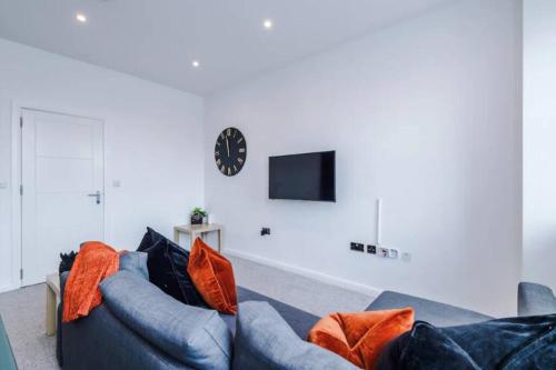 a living room with a couch and a clock on a wall at Stunning 2-Bedroom Apartment in Bolton in Bolton