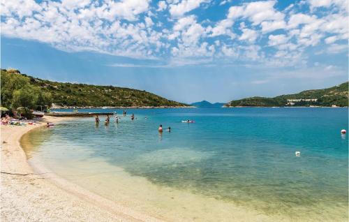 a group of people in the water on a beach at One-Bedroom Apartment In Slano in Slano