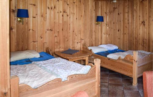 two beds in a room with wooden walls at Stallen 1 in Rauland