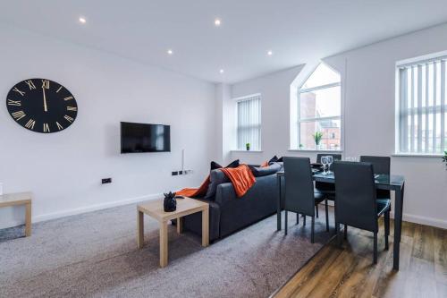 a living room with a couch and a table and a clock at Stunning 2-Bedroom Apartment in Bolton in Bolton