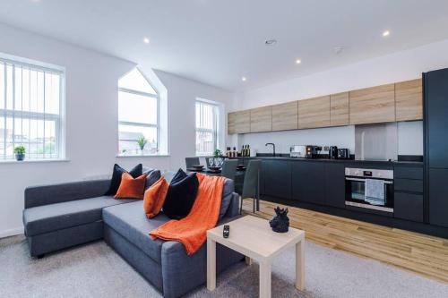 a living room with a blue couch and a kitchen at Stunning 2-Bedroom Apartment in Bolton in Bolton