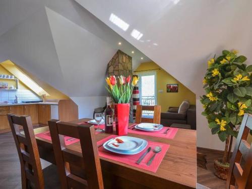 a dining room and kitchen with a table with plates and flowers at Zielone Zacisze in Krościenko
