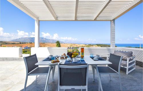 une table et des chaises sur une terrasse avec vue sur l'océan dans l'établissement Cozy Home In Partinico With Wifi, à Partinico