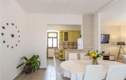 a kitchen and dining room with a white table and chairs at Lovely Home In Motovun With Sauna in Motovun