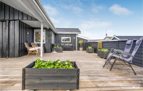a patio with a table and chairs on a wooden deck at 3 Bedroom Cozy Home In Hejls in Hejls
