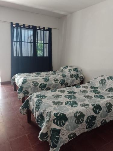 a room with two beds and a window at La Casona del Norte Jujuy in San Salvador de Jujuy