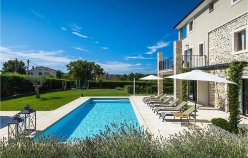 - une piscine avec des chaises et des parasols à côté d'une maison dans l'établissement Villa San Martino, à Rovinj