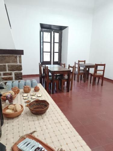 a dining room with tables and chairs and a table with food at La Casona del Norte Jujuy in San Salvador de Jujuy