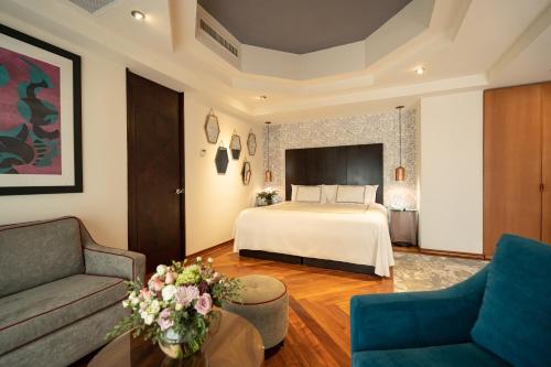 une chambre d'hôtel avec un lit et un canapé dans l'établissement Santa Rita Hotel del Arte, à Zacatecas