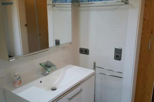 a white bathroom with a sink and a mirror at -Alirina- Ferienwohnung, 2 Schlafzimmern,Parkplatz in Oberkotzau