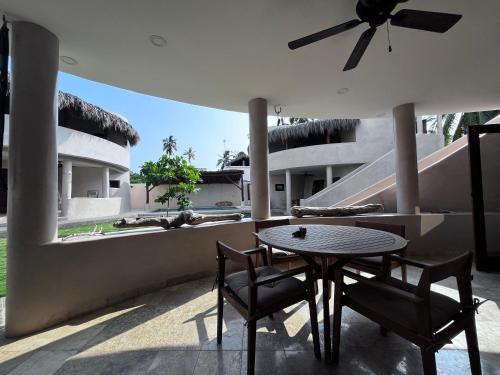 a patio with a table and chairs on a balcony at Villas Cononda in La Majahua