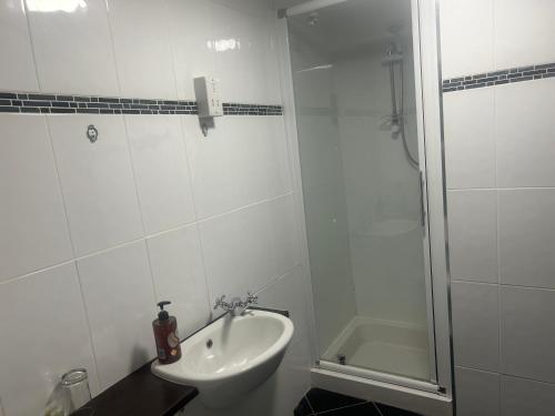 a white bathroom with a sink and a shower at The White Lion Inn in Penrith