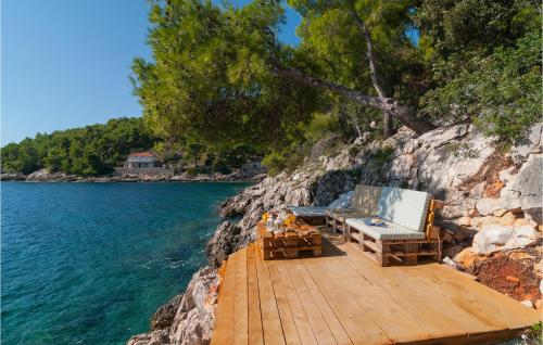 a wooden dock with a bench and chairs on the water at Holiday Home Gdinj With Sea View I in Gdinj