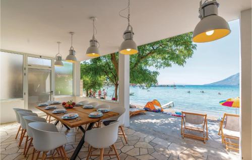 a dining room with a table and chairs and a view of the water at Holiday Home Zuljana 21 in Žuljana