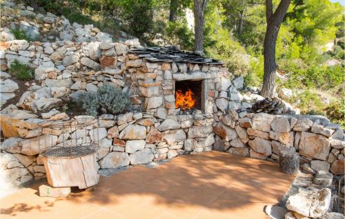 a stone oven with a fire in a stone wall at Holiday Home Gdinj With Sea View I in Gdinj