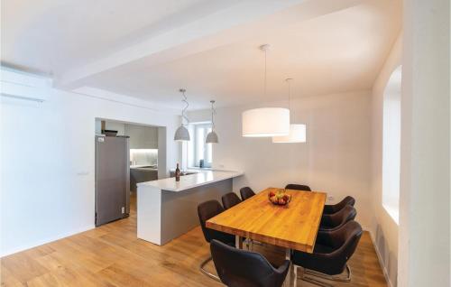 a dining room and kitchen with a wooden table and chairs at Holiday Home Zuljana 21 in Žuljana