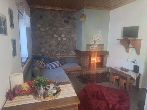 a living room with a fireplace and a table at Potamolithos Suites 2 in Konitsa