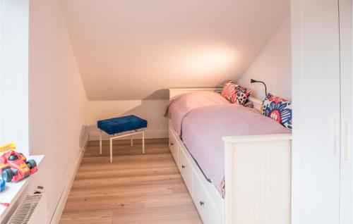a small attic bedroom with a bed and a chair at Haus Hilda in Grömitz