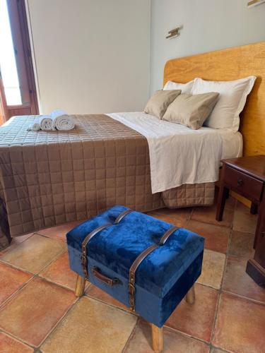 a blue suitcase sitting on the floor next to a bed at Le Scalette del centro in Agrigento