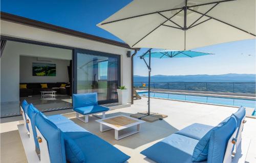 un patio con sillas azules y una sombrilla en Villa Panorama, en Buzet