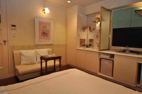 a living room with a couch and a television in a room at Hotel Boston Club (Adult Only) in Tokyo