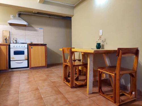 a kitchen with a table and chairs and a stove at Monoambiente Buena Vista - De Alojamientos Lago Puelo in Lago Puelo