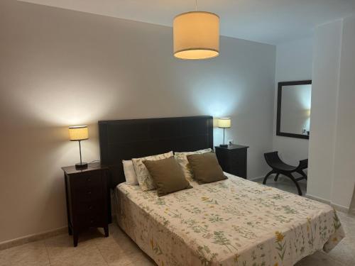 een slaapkamer met een bed met twee nachtkastjes en twee lampen bij Suite Cava in Arrecife
