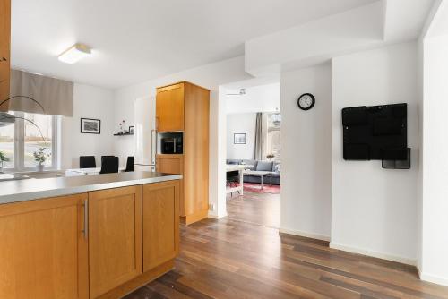a kitchen with wooden cabinets and a living room at HernöRum Franzéngatan - Centrala lägenheter in Härnösand