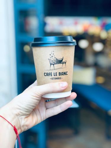 a hand holding a cup of coffee in a store at Hostel Le Banc in Istanbul