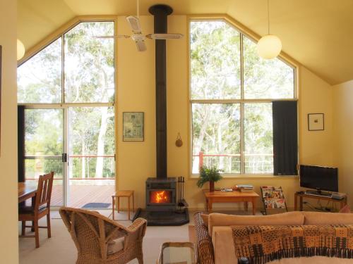 a living room with a couch and a fireplace at Bundle Hill Cottages in Bawley Point