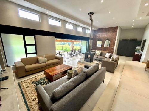 a large living room with couches and a fireplace at Highland Peace Haven In Dullstroom in Dullstroom